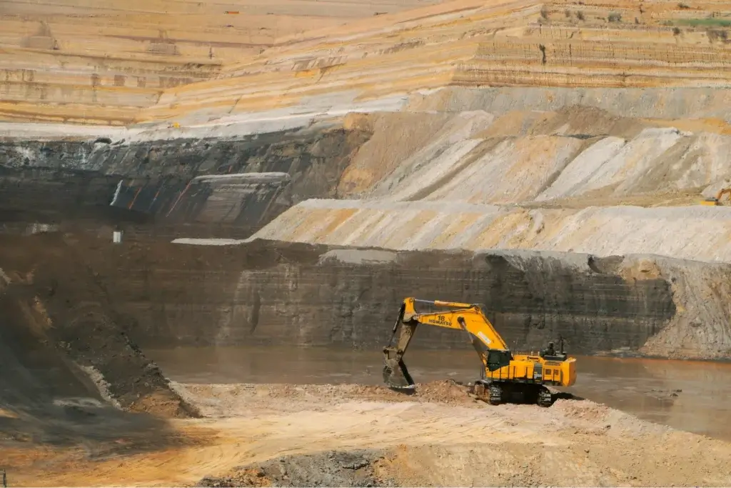 A lone excavator sitting in an open mine.