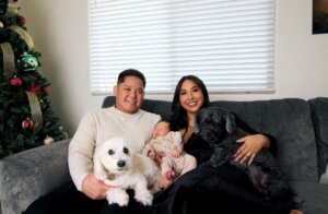 Jessica and Jerico at home with their baby and dog on a couch