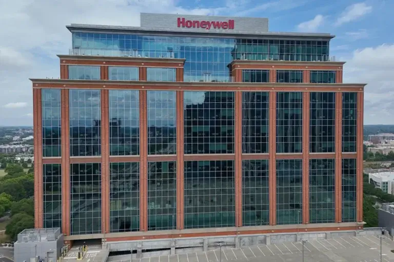 Aerial view of a Honeywell office building with large glass windows and the Honeywell logo displayed on the rooftop.