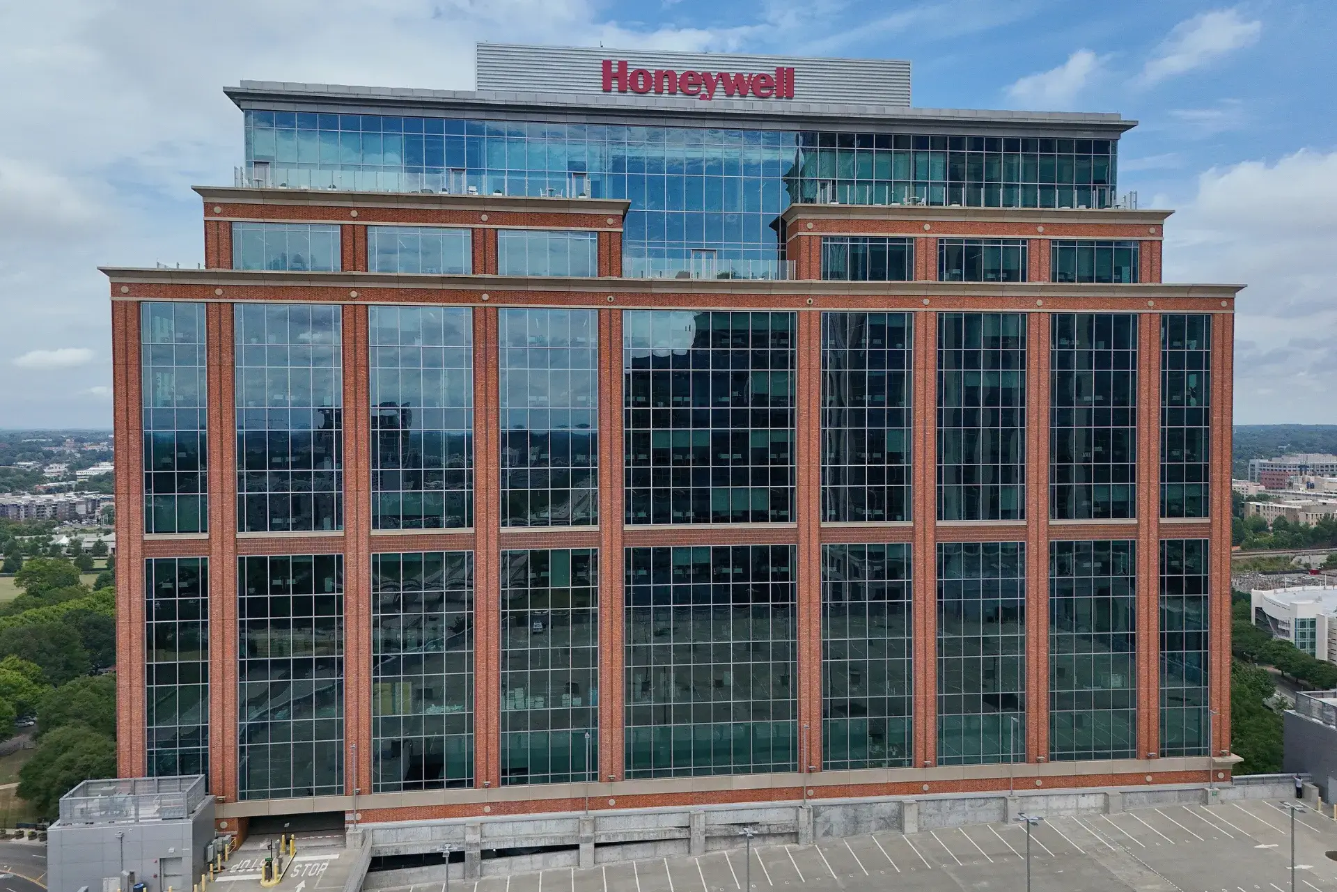 Aerial view of a Honeywell office building with large glass windows and the Honeywell logo displayed on the rooftop.